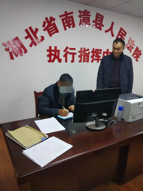 图：被执行人签字（右为执行干警徐明才）_副本.jpg